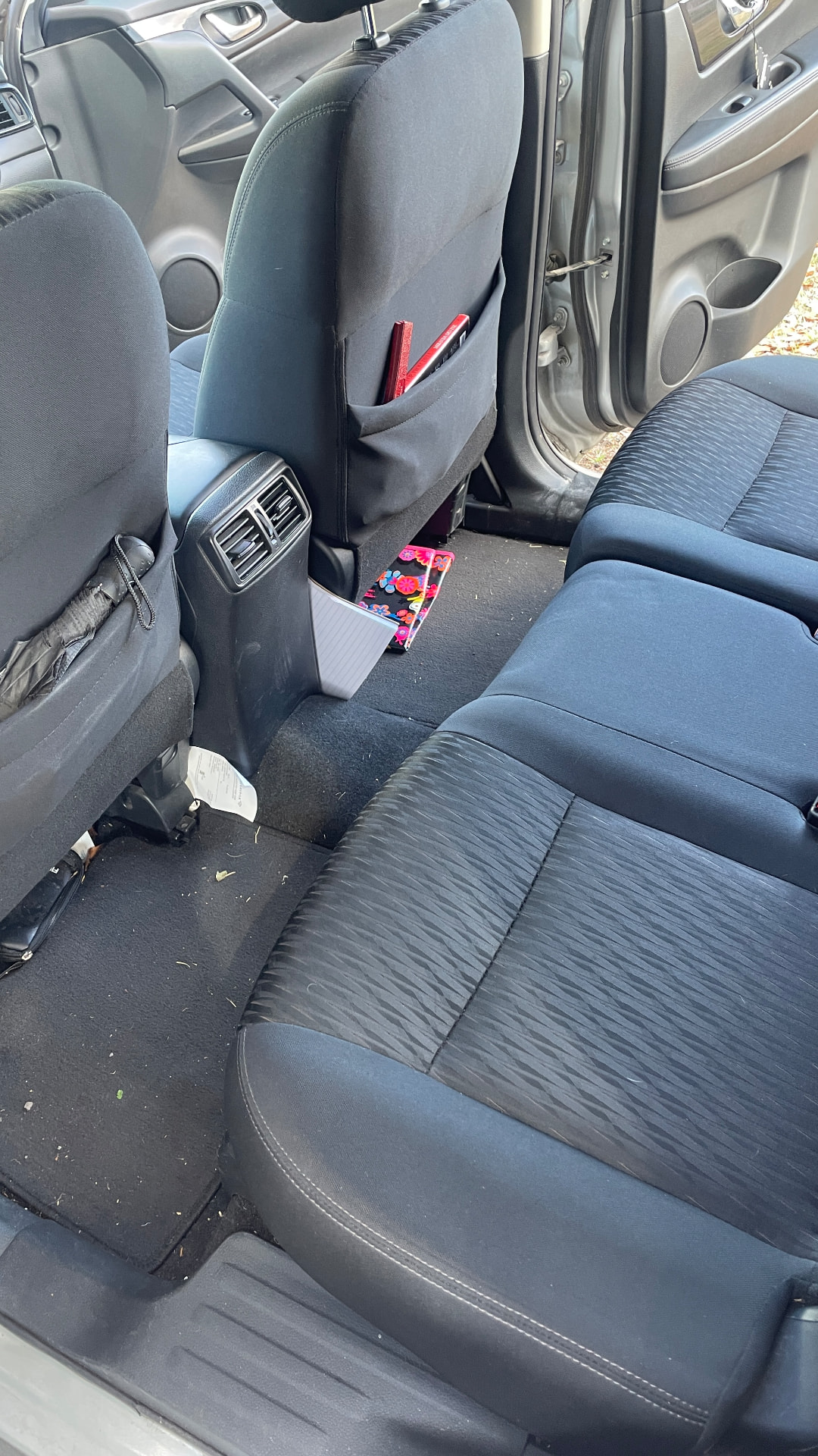 Cluttered back seat with trash before detailing